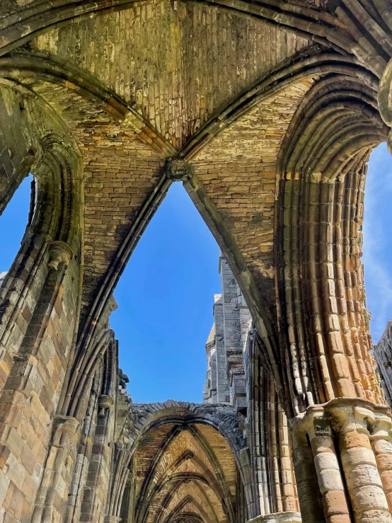 a large stone cathedral with three windows and a sky background