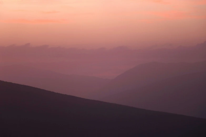 a small kite flying in the sky above a mountain