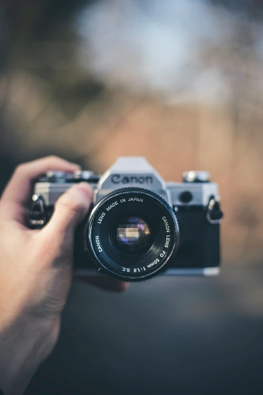 someone holding an old camera taking a po