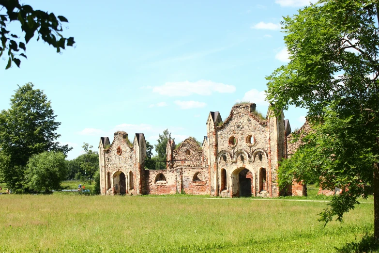 an old ruin sitting on a green grass covered hill