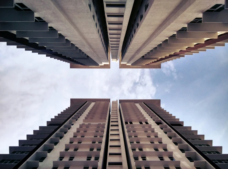 looking up at some tall buildings against a blue sky