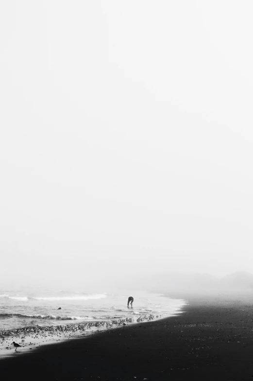 a person on the beach, holding a surf board in the sand