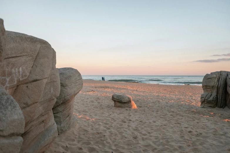 two big rocks on a beach near the ocean