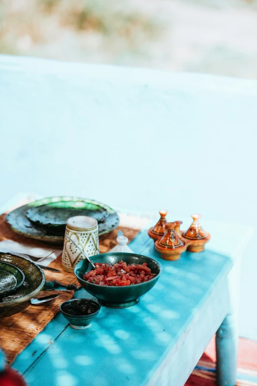 a blue table filled with food and dishes