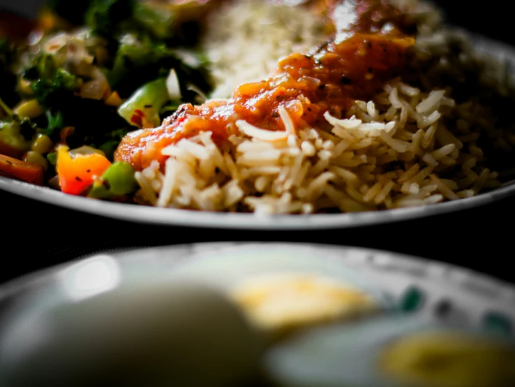 some white plates of food with rice, broccoli and tomatoes