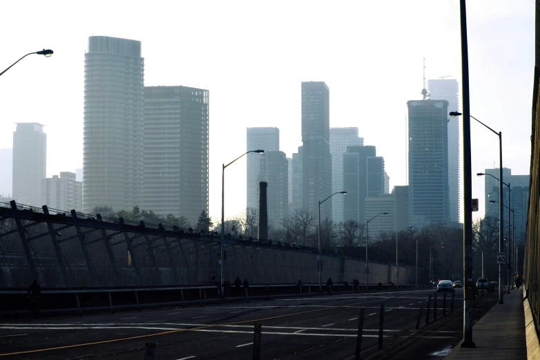 an empty highway with a cityscape in the background