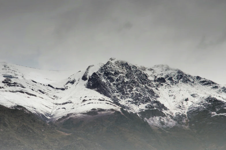 a large snow covered mountain with a few birds sitting on top