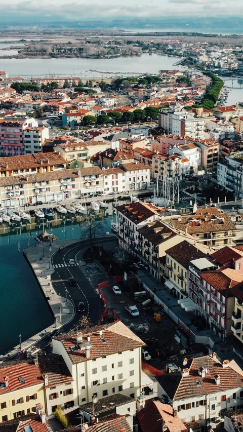 a city with some red roofs next to the ocean