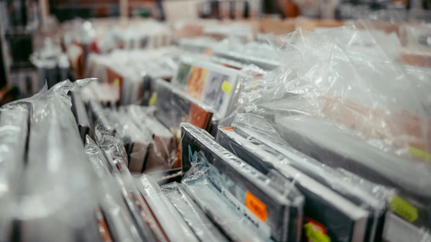 various types of cds and cases with plastic bags sitting on them