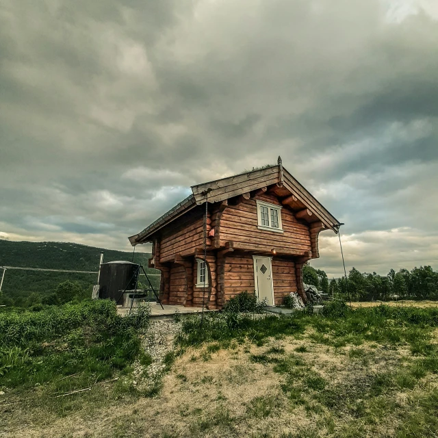 a log cabin nestled in the middle of a valley