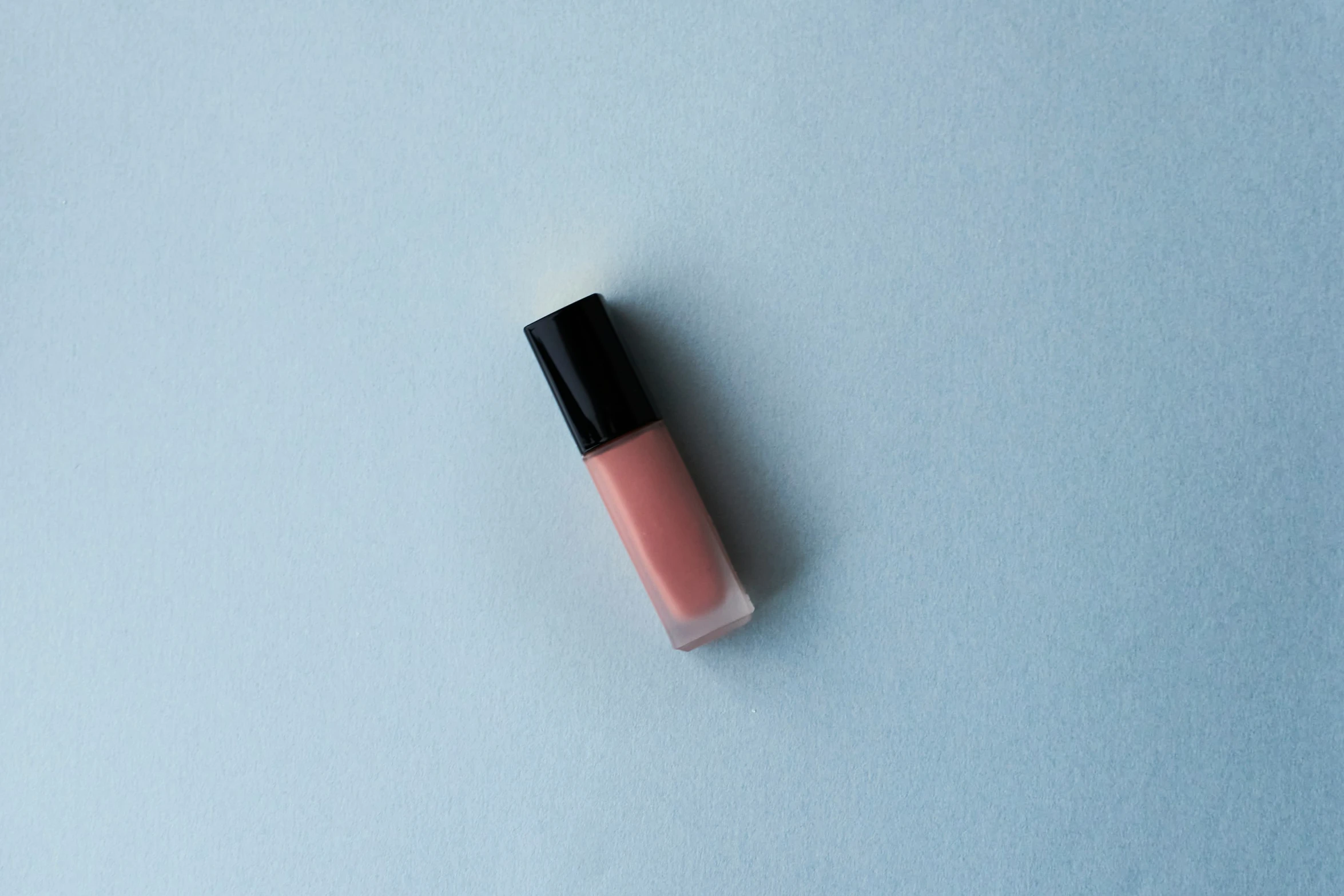 a pink lip sitting on top of a blue background