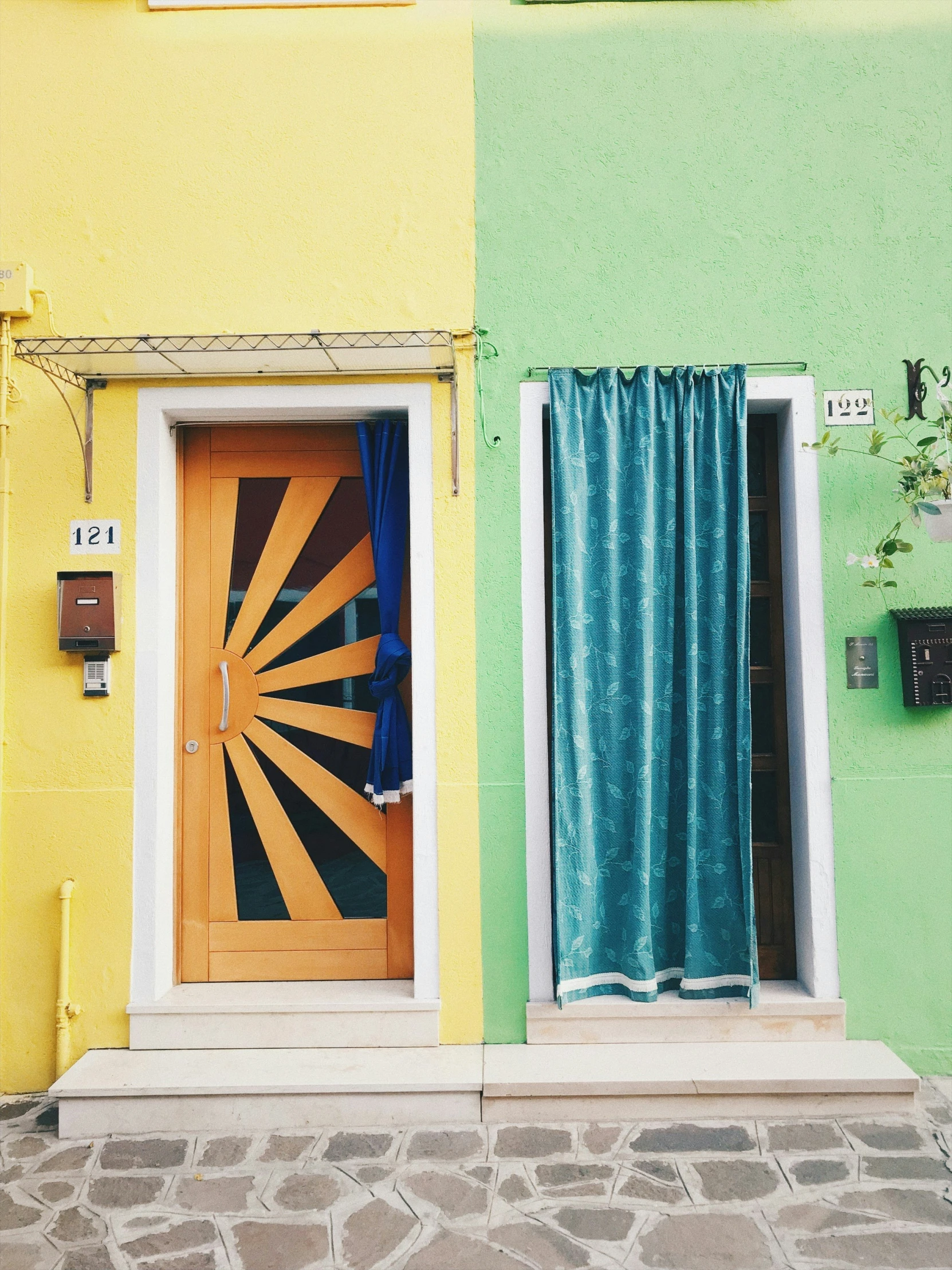 a wooden door is in front of an open green and yellow building