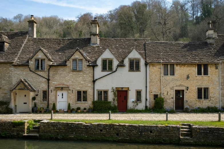 a stone building has two stories and a doorway with three windows