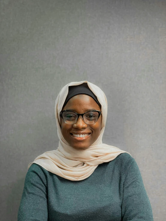 a smiling woman wearing glasses and a scarf