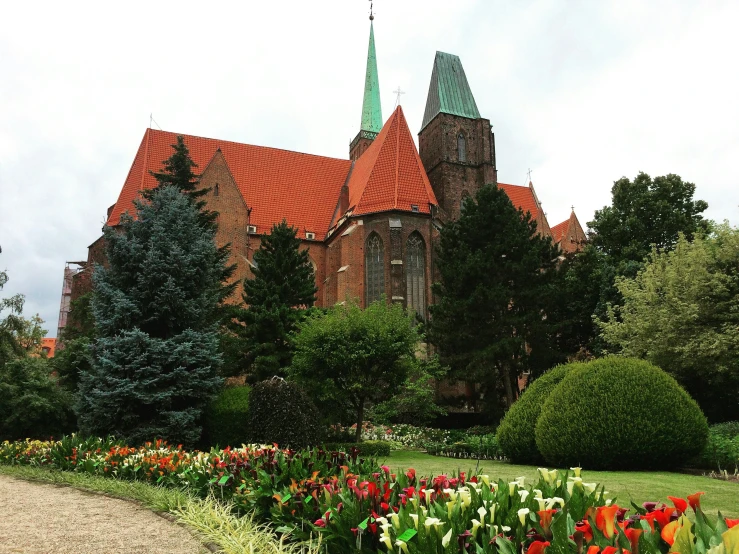 a flower garden in front of an old church