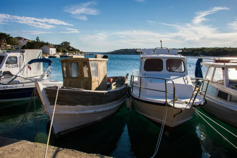 several boats in the water one being tied to a dock