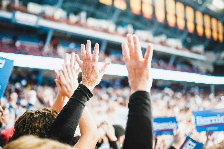 many people are clapping in front of the crowd