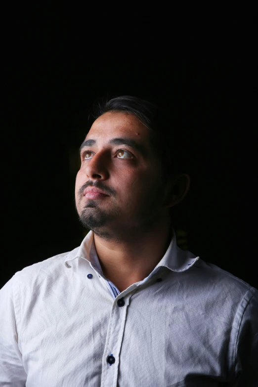 a man in a white shirt stares at the sky