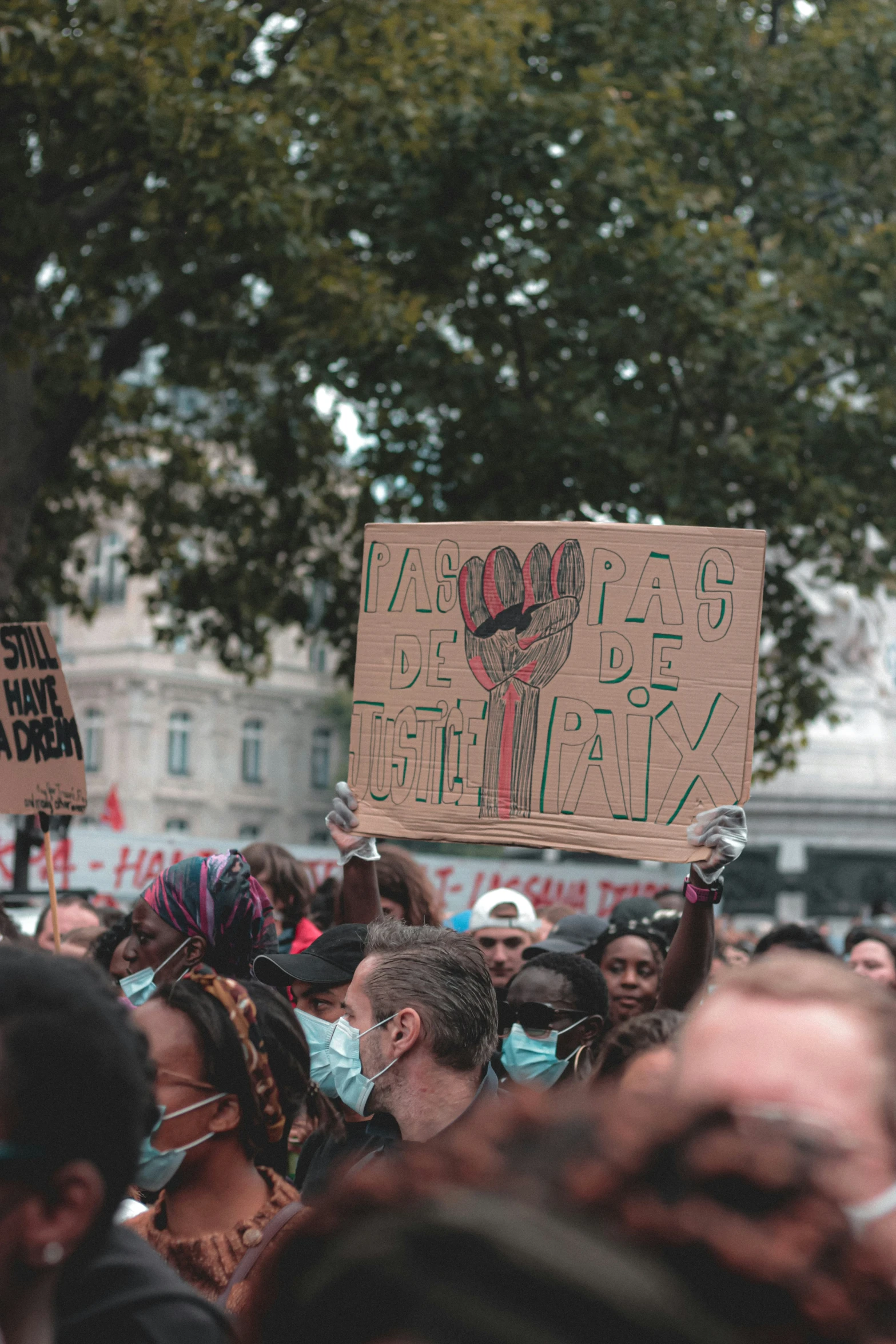 a crowd of people at an occupy - it protest with a sign