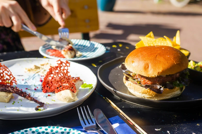 plates hold burgers as they are displayed on tables