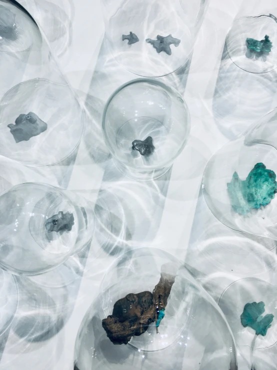 several glass bowls filled with blue and green decorations