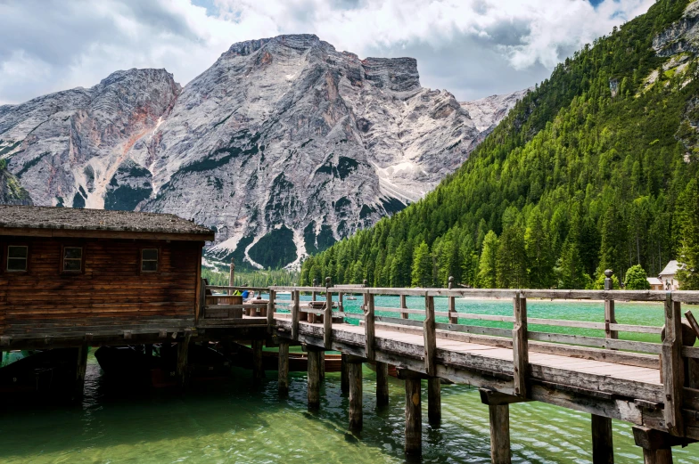 a wooden pier in front of some mountains