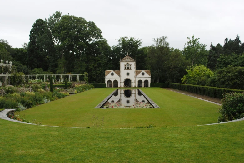 a garden is shown with a pool surrounded by trees