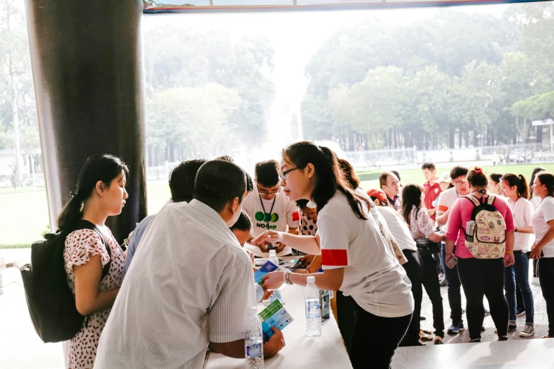 some people are in line at a water fountain