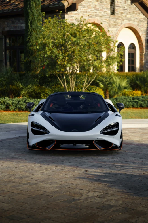 a white sports car sitting outside a luxurious house