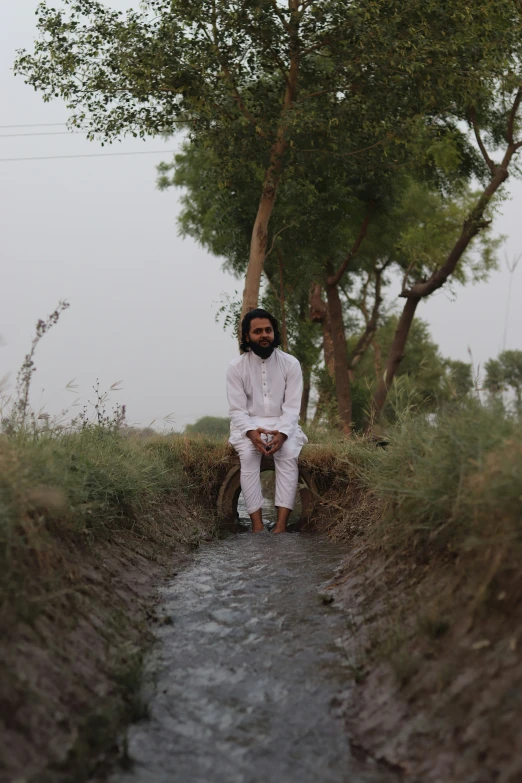 a man sits in front of a forest