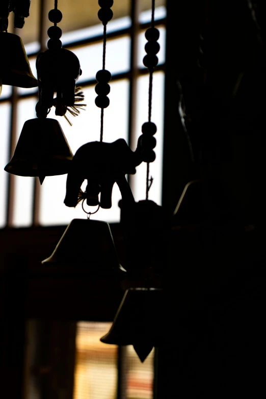 a silhouetted window with a number of bells