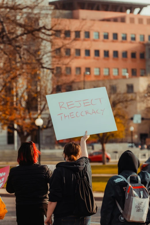 a group of people holding signs on the street