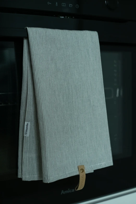 two pieces of cloth hang from the handle of a microwave