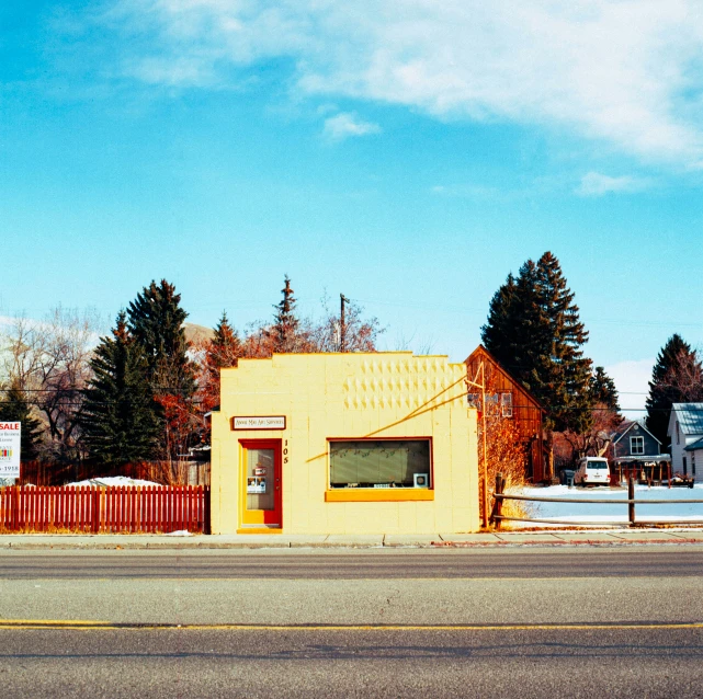 a yellow building is sitting beside the street