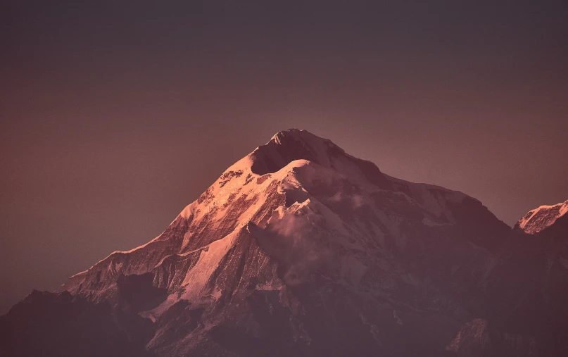 a snow capped mountain has snow on it's summit