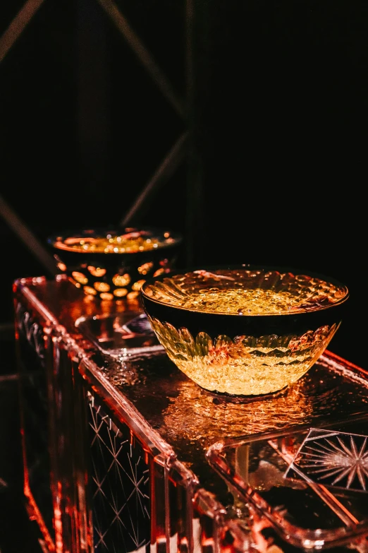 an intricate gold bowl on top of a red table