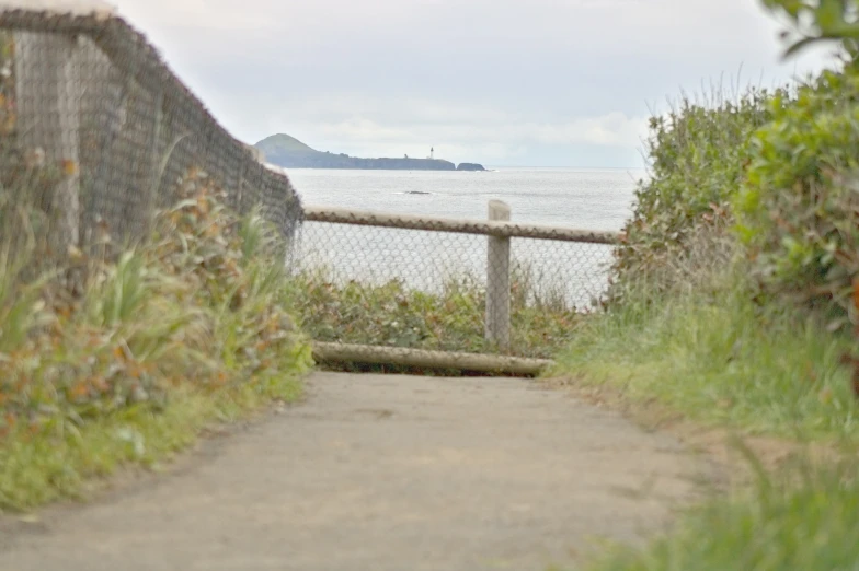 a road next to the water on a cloudy day