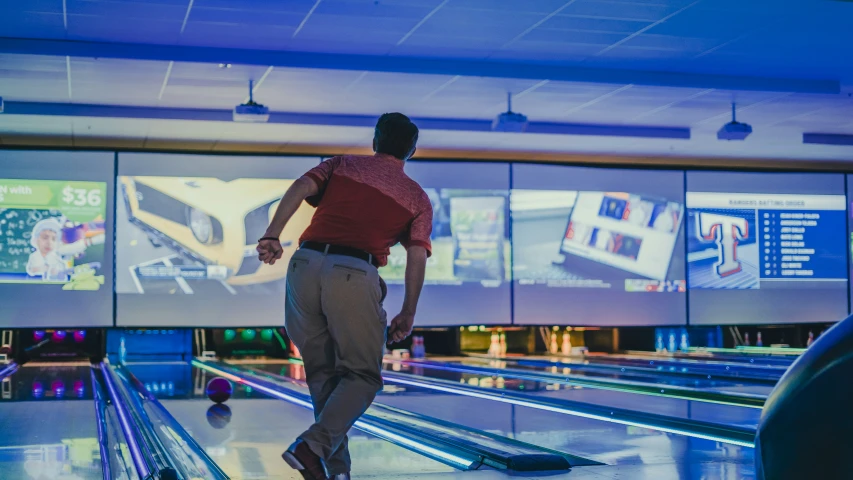 a man is bowling down a line of pins in a bowling alley