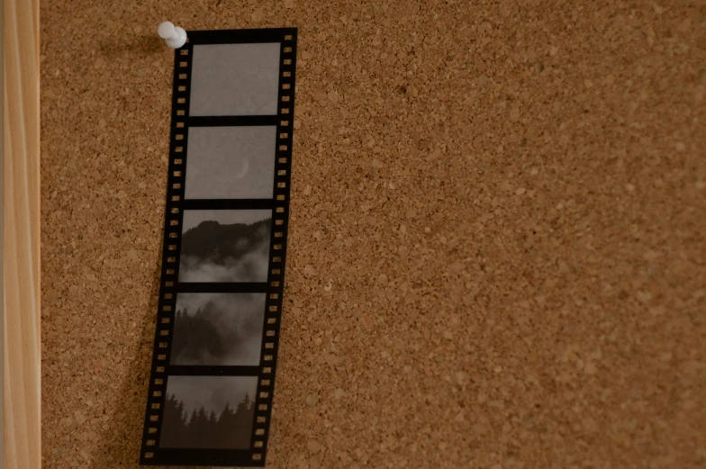 a movie strip laying against a cork board