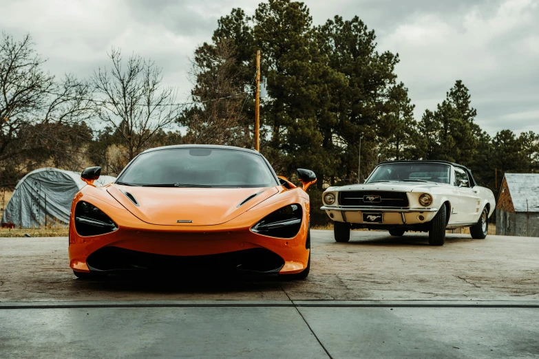 two cars one white and one orange are parked