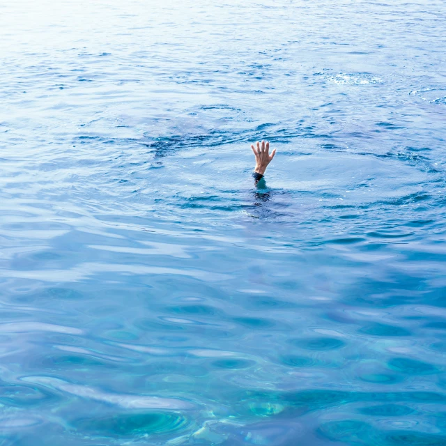 person wearing orange swimming in calm ocean water