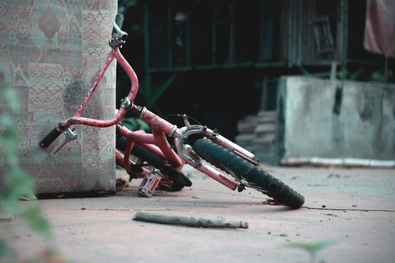 a red bicycle  to the side of a wall