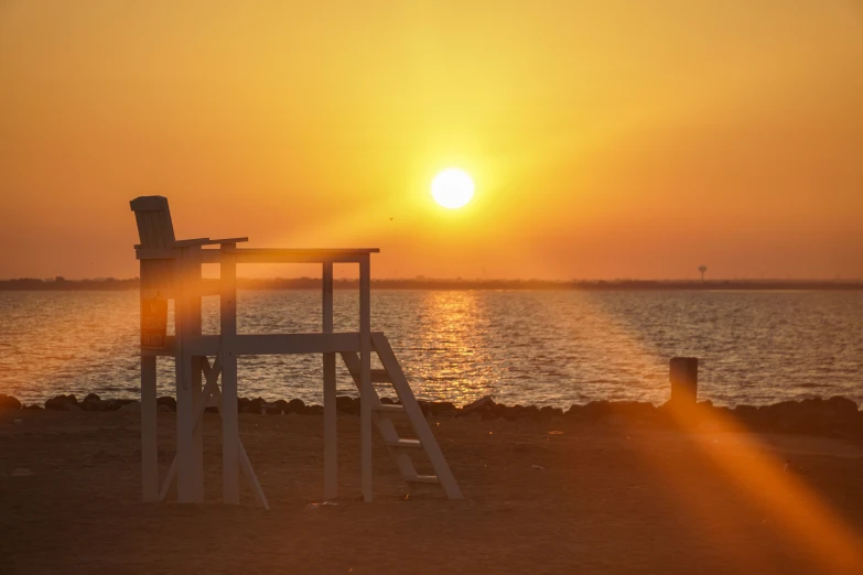 a row of chairs sitting on top of a beach