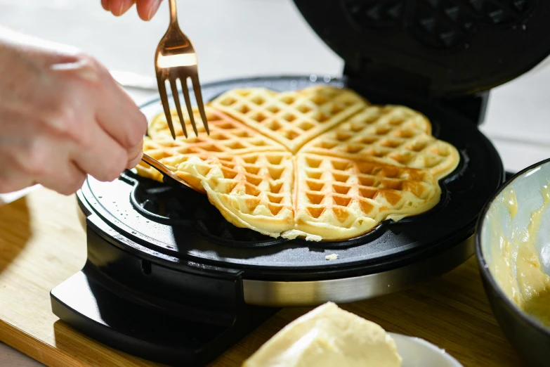 a person is taking some food out of a waffle pan