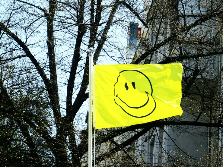 a yellow street sign that has a smiling face drawn on it