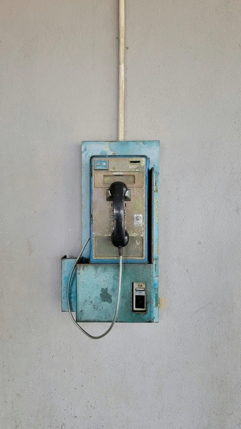 a very old fashioned telephone hanging from a wall