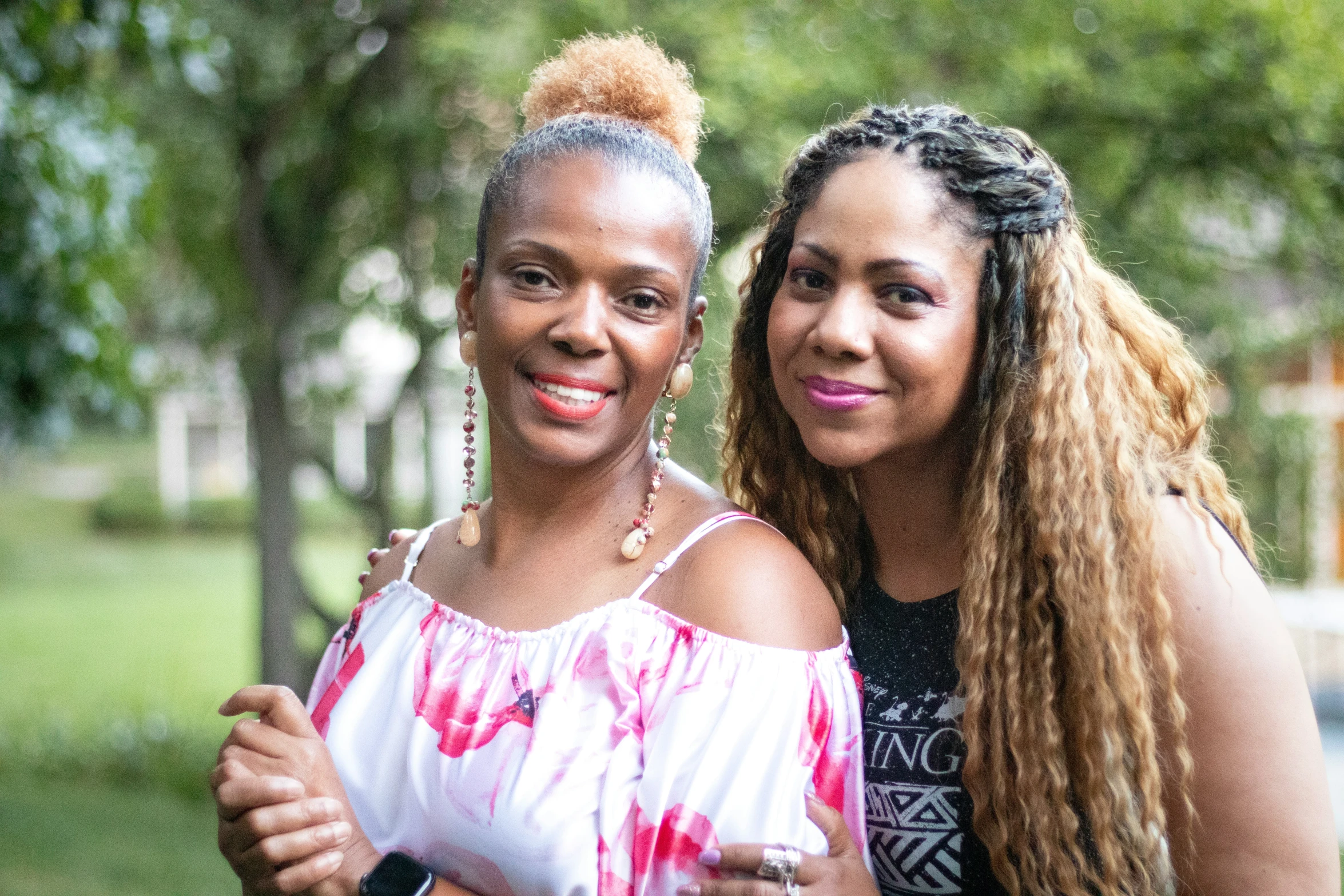 two women smiling for the camera on a rainy day