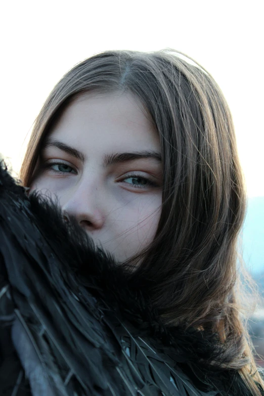 a woman wearing a large coat and fur with long fringes