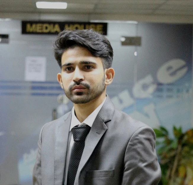 an indian man in business suit standing in a room