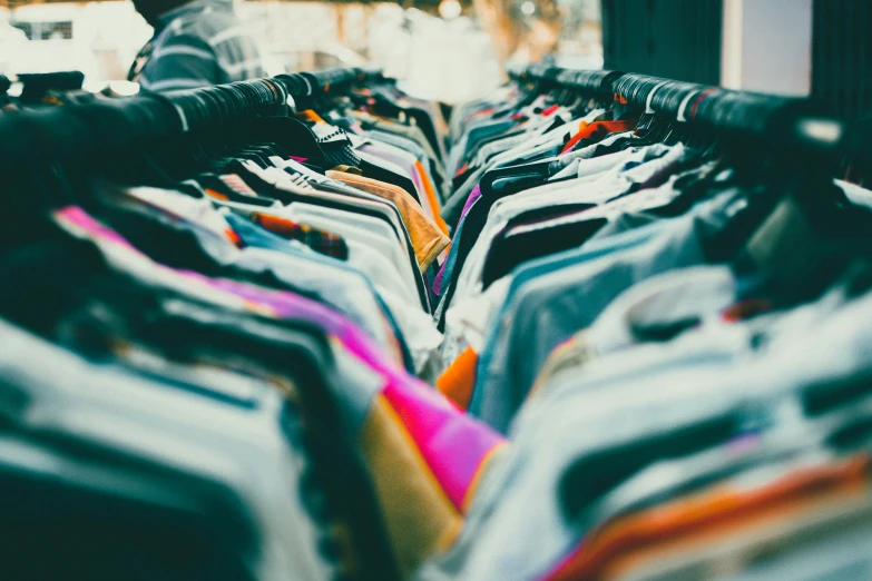 a long line of clothing on a rack in a store